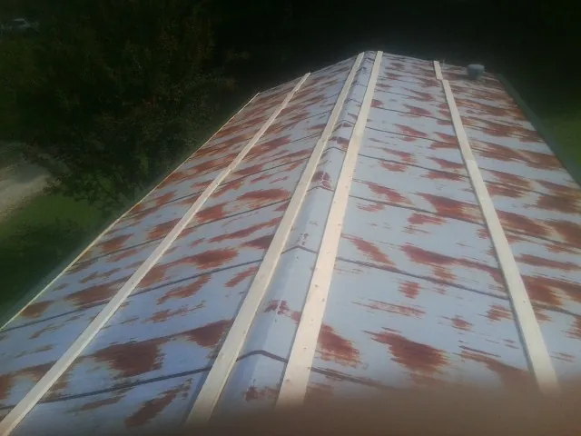 Rusted metal roof panels with new wood purlins before replacement — Storm Damage Roof Repair in Cabins by Roofing Brothers